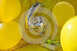 Celebration yellow background, a gift box with ribbon, magic ball and wand. Copy space.