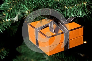 Celebratory gift hanging on Christmas fir-tree photo