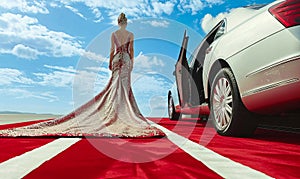 Celebrity woman in long fashionable luxury gown walking on a red carpet to celebrity gala event