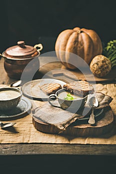 Celery cream soup and toast, fresh pumpkin at background