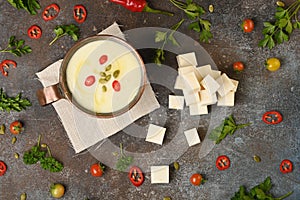 Celery root soup in copper cup on dark background.