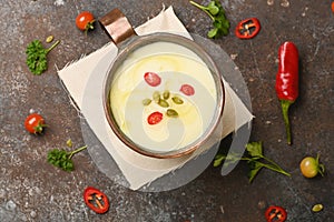 Celery root soup in copper cup on dark background.