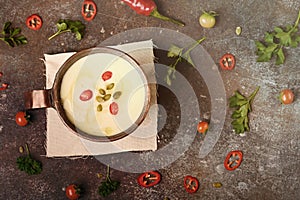 Celery root soup in copper cup on dark background.