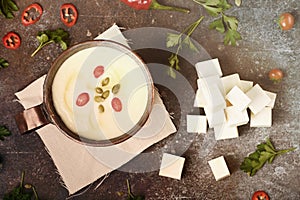 Celery root soup in copper cup on dark background.