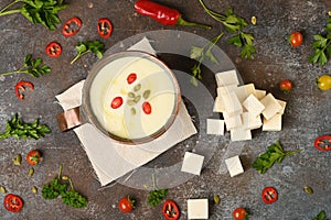 Celery root soup in copper cup on dark background.