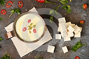 Celery root soup in copper cup on dark background.