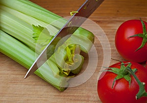 Celery and tomatoes on a cutting board