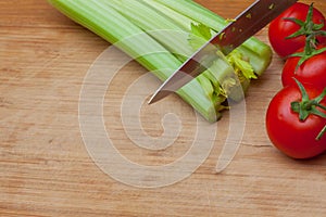 Celery and tomatoes on a cutting board