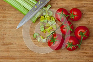 Celery and tomatoes on a cutting board