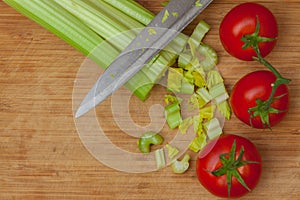 Celery and tomatoes on a cutting board