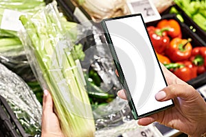 Celery vegetable in hand and smartphone  white