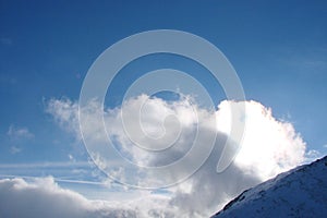 Mountain ridge High Tatras. Slovakia. Panorama of the cloudy blue winter sky above the snow-capped peaks of the High Tatras.