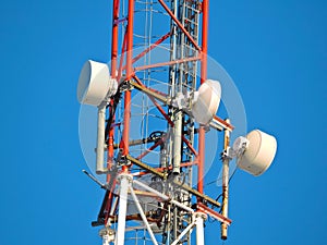 Cell antenna, transmitter. Telecom TV radio mobile tower against blue sky