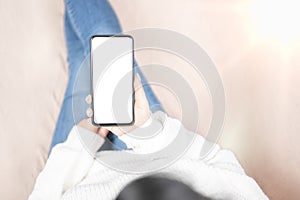 Cell phone blank white screen mockup. woman hand holding texting using mobile on sofa at home.background empty space for advertise