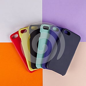 Cell phone cases various colors on multicolor paper background photo