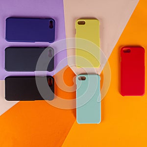 Cell phone cases various colors on multicolor paper background