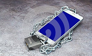 cell phone is locked. blocking social networks and mobile application. smartphone is covered with a chain and padlock.