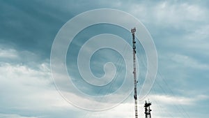 Cell phone tower and rainy sky with gray clouds, time lapse. Background of sky and clouds over the Tower of Mobile