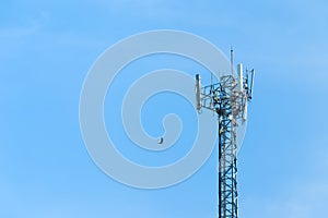 Cell phone tower rises against a blue sky.