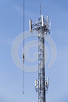 Cell phone tower rises against a blue sky.