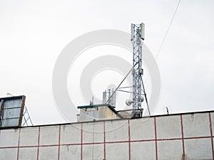 Cell phone tower on the roof of a building. The concept of abundant internet. Antenna for cell phone communication