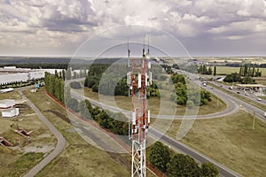 Cell site of telephone tower with 5G base station transceiver by highway intersection