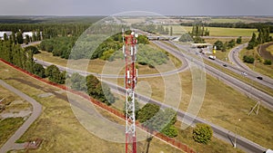 Cell site of telephone tower with 5G transceiver by highway intersection