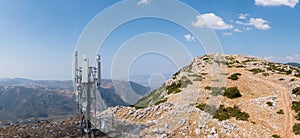 Cell tower. Mobile phone antenna aerial view. Rocky mountain and blue sky