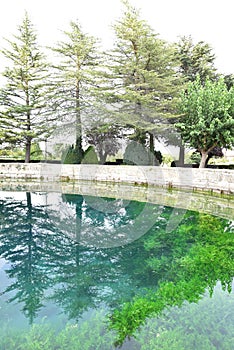 Cella fountain reflecting the trees of the park in the water, photo