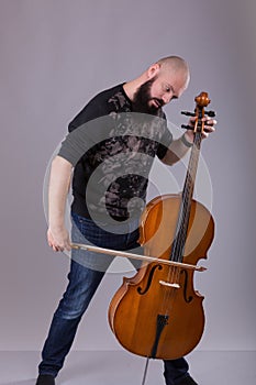 Cellist playing classical music on cello. bearded man fooling around with a musical instrument