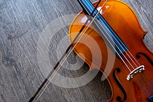 The cello and its bow are on a wooden background. Top view. Rehearsal before the concert. Musical tuition concept