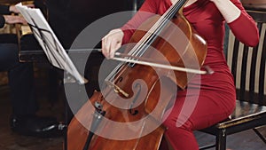 Cello player. Cellist hands playing cello with bow.