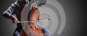 Cello player or cellist performing in an orchestra background