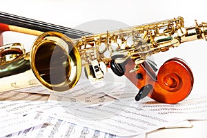 Cello tuning pegs and shiny golden alto saxophone