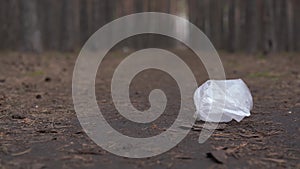 Cellophane bag on ground in forest. Concept of environmental pollution.