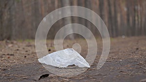 Cellophane bag on ground in forest. Concept of environmental pollution.