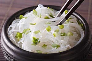Cellophane noodles with green onions in a bowl closeup. horizontal