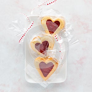 Cellophane wrapped raspberry filled Linzer cookies for Valentine& x27;s Day. photo