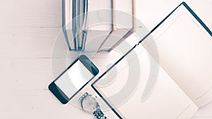 Cellphone with stack of book and watch vintage style