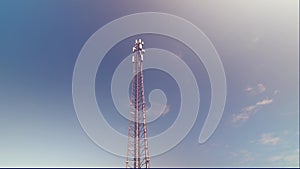 Cellular antenna tower and electronic radio transceiver equipment part of a cellular network under the blue sky. 4K Time lapse
