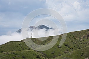 Cellular antennas on a green slope on the background of mountains in the clouds on the Crimean Peninsula