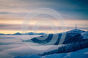 Cellular communications tower on mountain. Sunrise on the horizon.