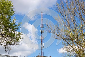 Cellular network or mobile antenna in the roof of a building, on cloudy sky