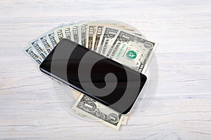 Cellular phone and American dollar money on white