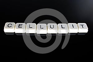 Cellulit text word title caption label cover backdrop background. Alphabet letter toy blocks on black reflective