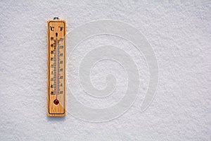 Celsius and Fahrenheit thermometer on the surface of white pure snow. Copy space