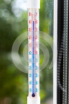 A Celsius thermometer shows high temperatures during heat waves outside. Conceptual photo of heat, warm weather