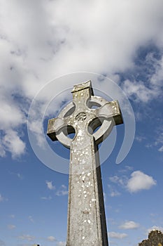 Celtic cross in an irish graveyard with blue sky