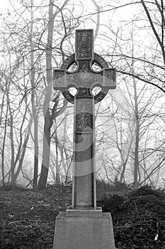 Celtic Cross in very foggy graveyard