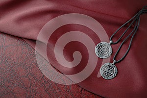 Celtic pendants on red silk cloth on leather book. photo